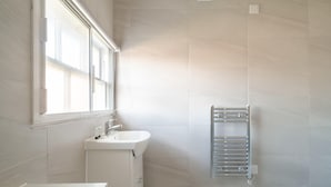 A bathroom with a window, a sink, and a towel rack. - Charming 1 Bedroom Apartment in Central Liverpool (Liverpool)