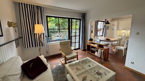 A modern hotel room with a large window, a dining area, and a glass display case with seashells. - Experience Frisian coziness in Haus Siril and the Kombüse apartment on Wangerooge (Wangerooge)