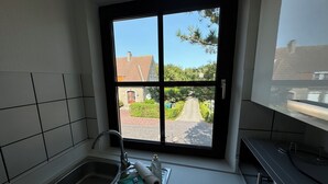 A kitchen with a window, a sink, and a stove. - Oberdeck - Friesische Gemütlichkeit (Wangerooge)