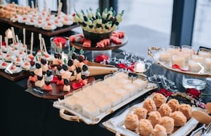 A buffet with various food items including skewers, desserts, and beverages.