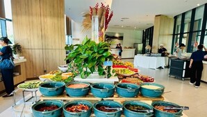 A buffet setup with various food items and a decorative centerpiece. - The Sea View Cam Ranh (Bac Cam Ranh)