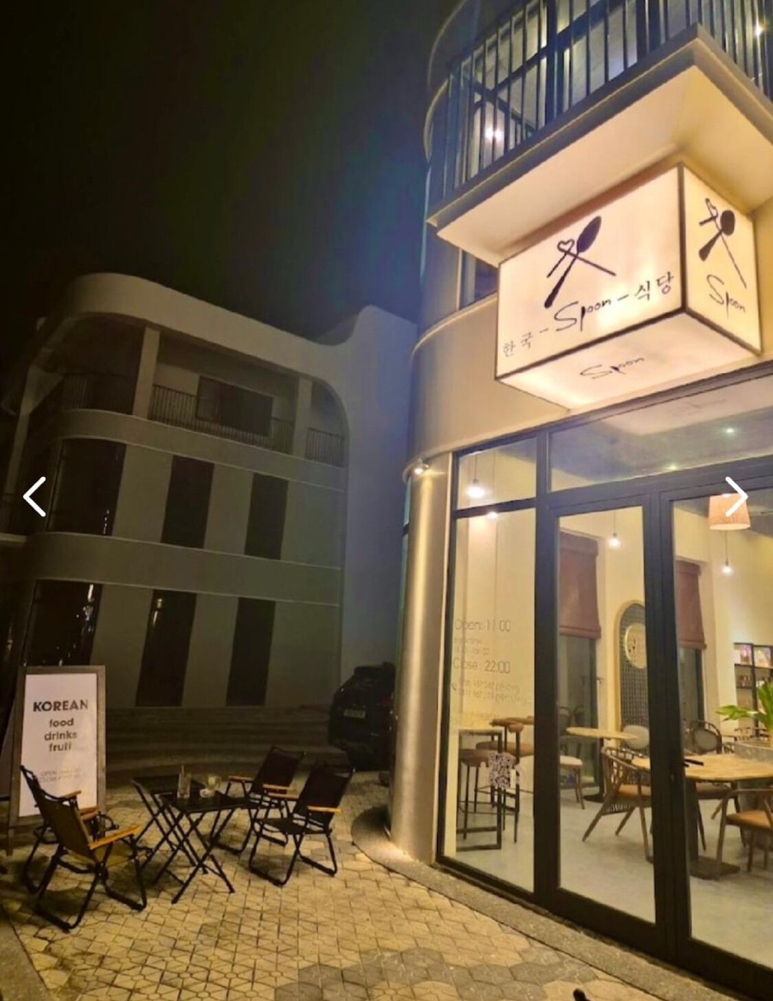 A Korean restaurant with outdoor seating and a sign indicating it offers food, drinks, and fruit.