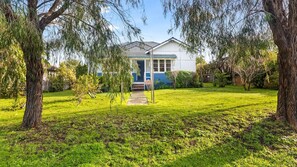 A house with a front yard, a visible garage, and a pathway leading to the entrance. - Park Rise Cottage: Your Cozy Coastal Escape in Busselton (Busselton)