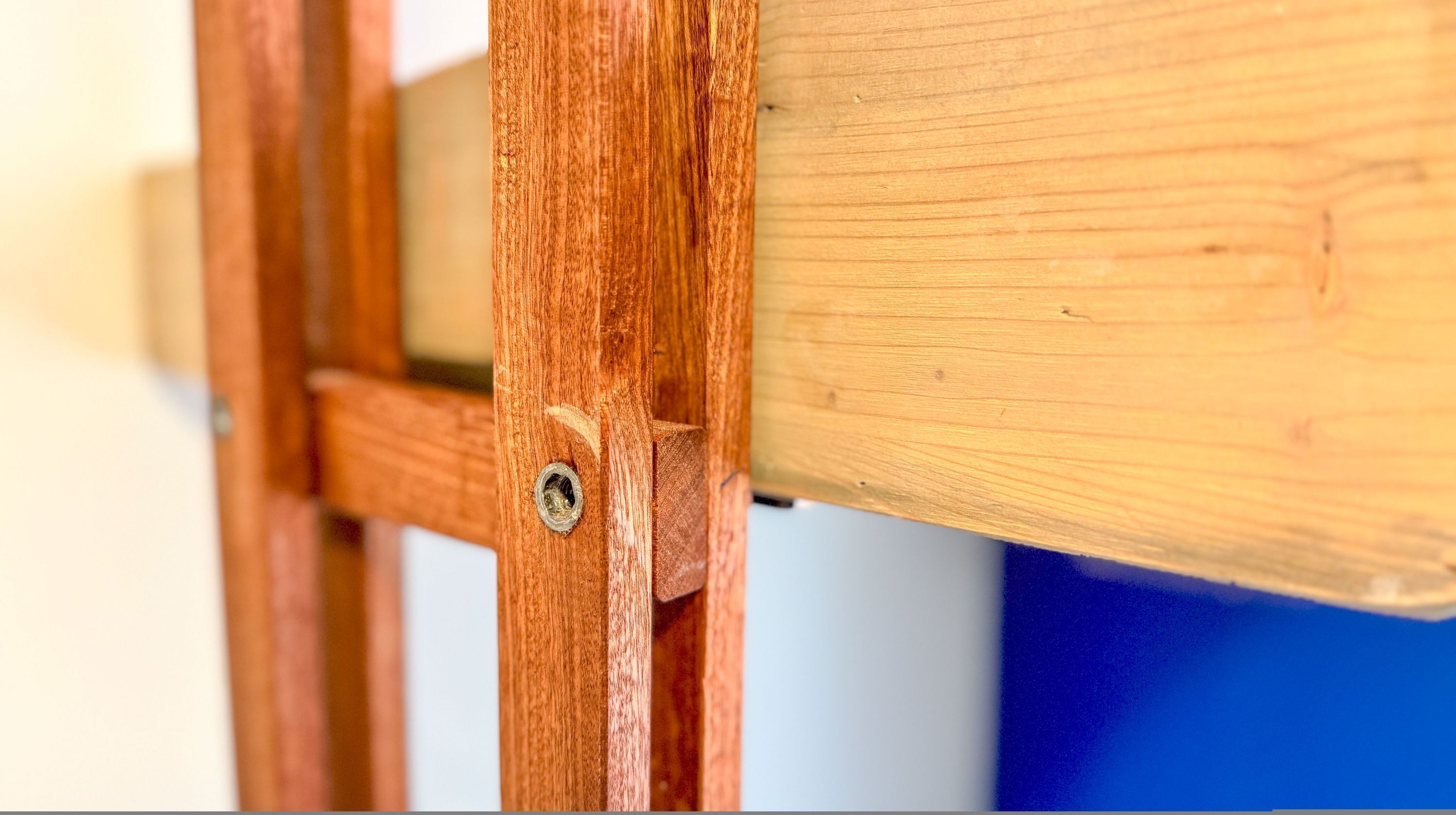 Gros plan d’une structure en bois, sur laquelle on peut voir une vis et une plaque métallique.