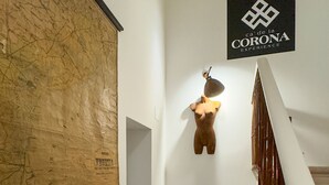 Un couloir avec une carte accrochée au mur, une chaise et un panneau sur lequel on peut lire : « CA’DE LA CORONA EXPERIENCE ».