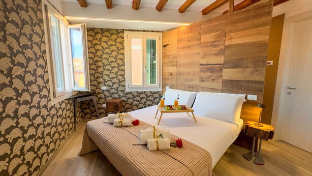 Un dormitorio con cama, mesita de noche y ventana.