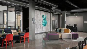 A modern interior with a seating area, a reception desk, and a wall with a unique design.