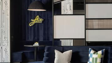 A modern lounge area with a blue sofa, a round table, and a decorative lamp.