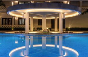 A pool area with a circular structure, columns, and a bar area.