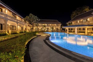 Una piscina al aire libre, sombrillas, tumbonas