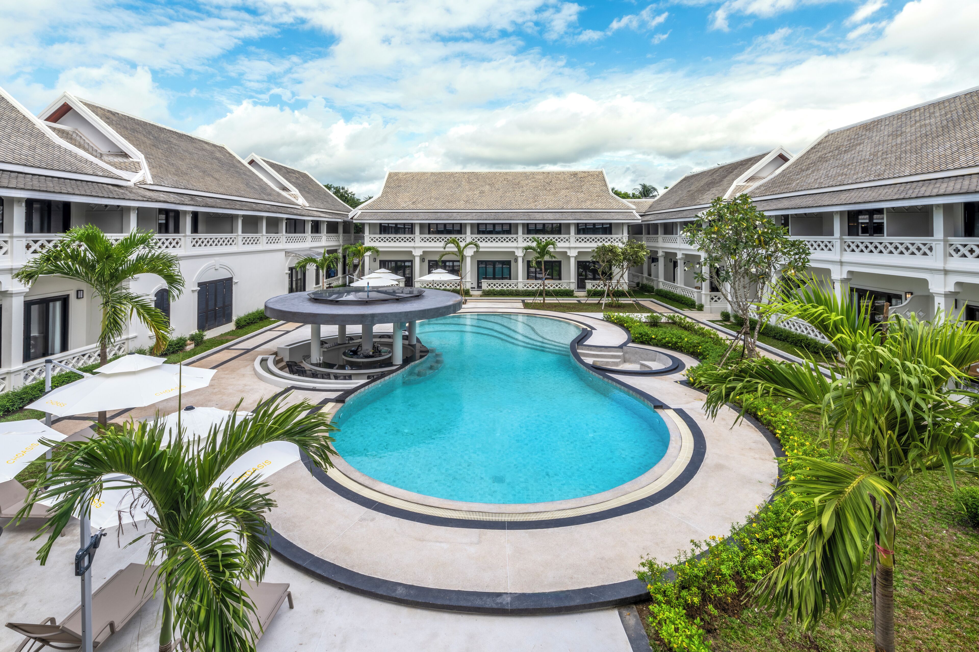 Una piscina al aire libre, sombrillas, tumbonas