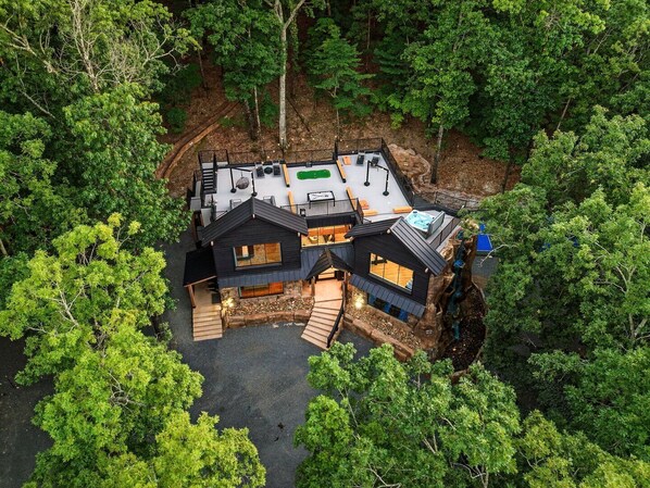 Une maison moderne dotée d’une terrasse, d’un jacuzzi et d’une cheminée en pierre.