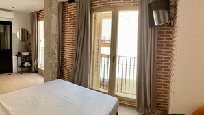 A bedroom with a bed, a bathroom with a sink and mirror, and a balcony with a view. - Exterior Studio 3rd floor (Málaga)