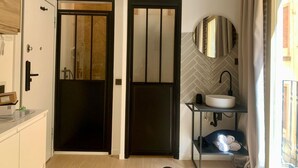 A modern bathroom with a black door, a white sink, and a mirror on the wall. - Exterior Studio 3rd floor (Málaga)