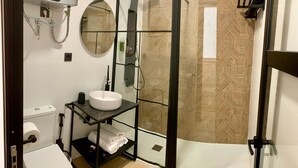 Une salle de bain moderne avec une douche à parois de verre, un lavabo blanc et un porte-serviettes.