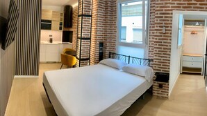 Une chambre à coucher avec un lit, un bureau, une chaise et une fenêtre.