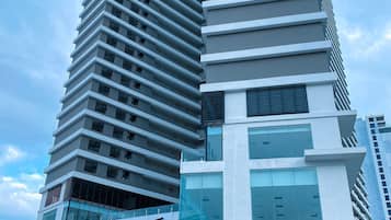 Een modern hoogbouwgebouw met een uniek getrapt ontwerp, met meerdere balkons en grote ramen.