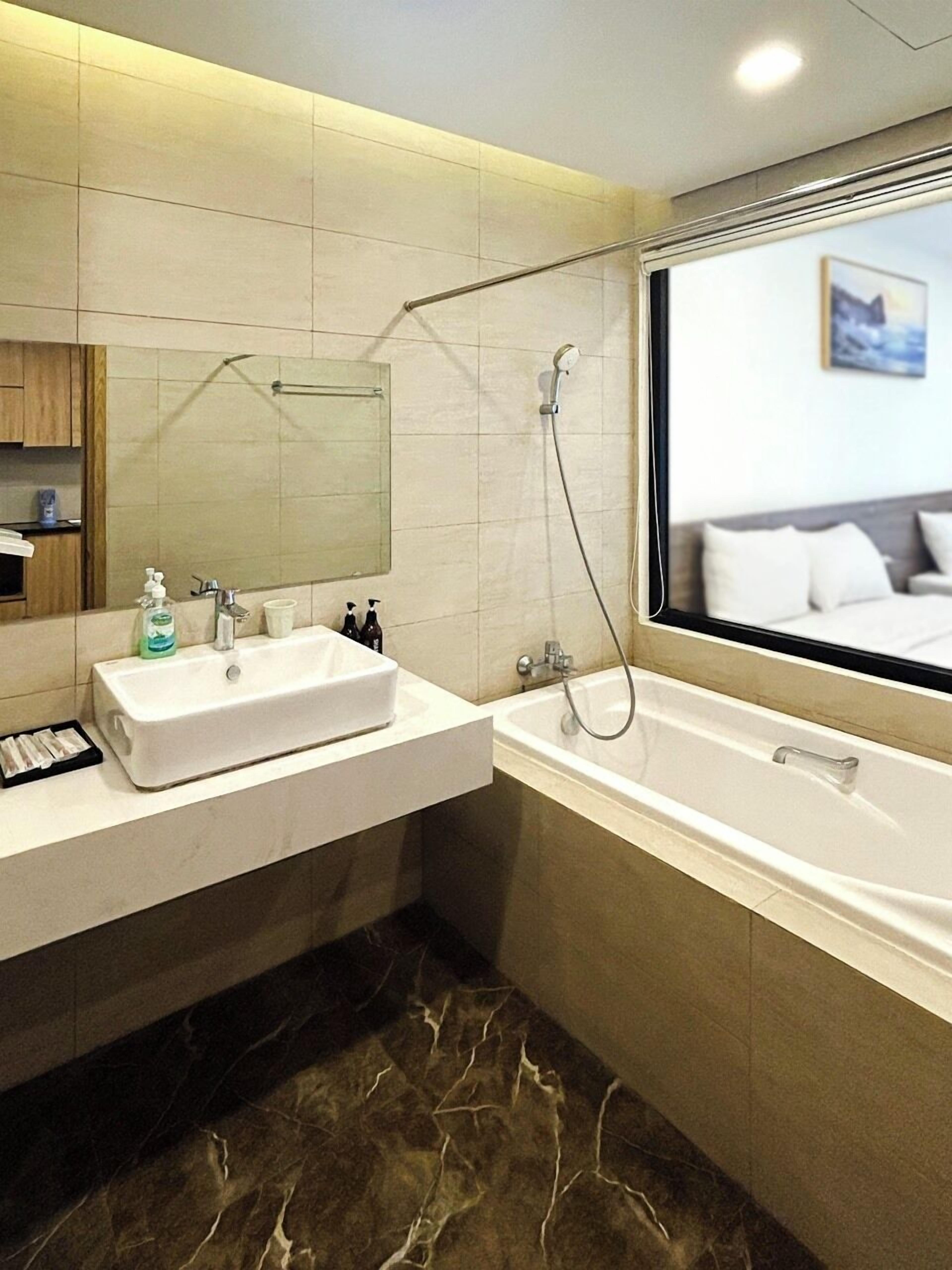 Un bagno moderno con uno specchio grande, un lavandino, una vasca da bagno e una doccia.