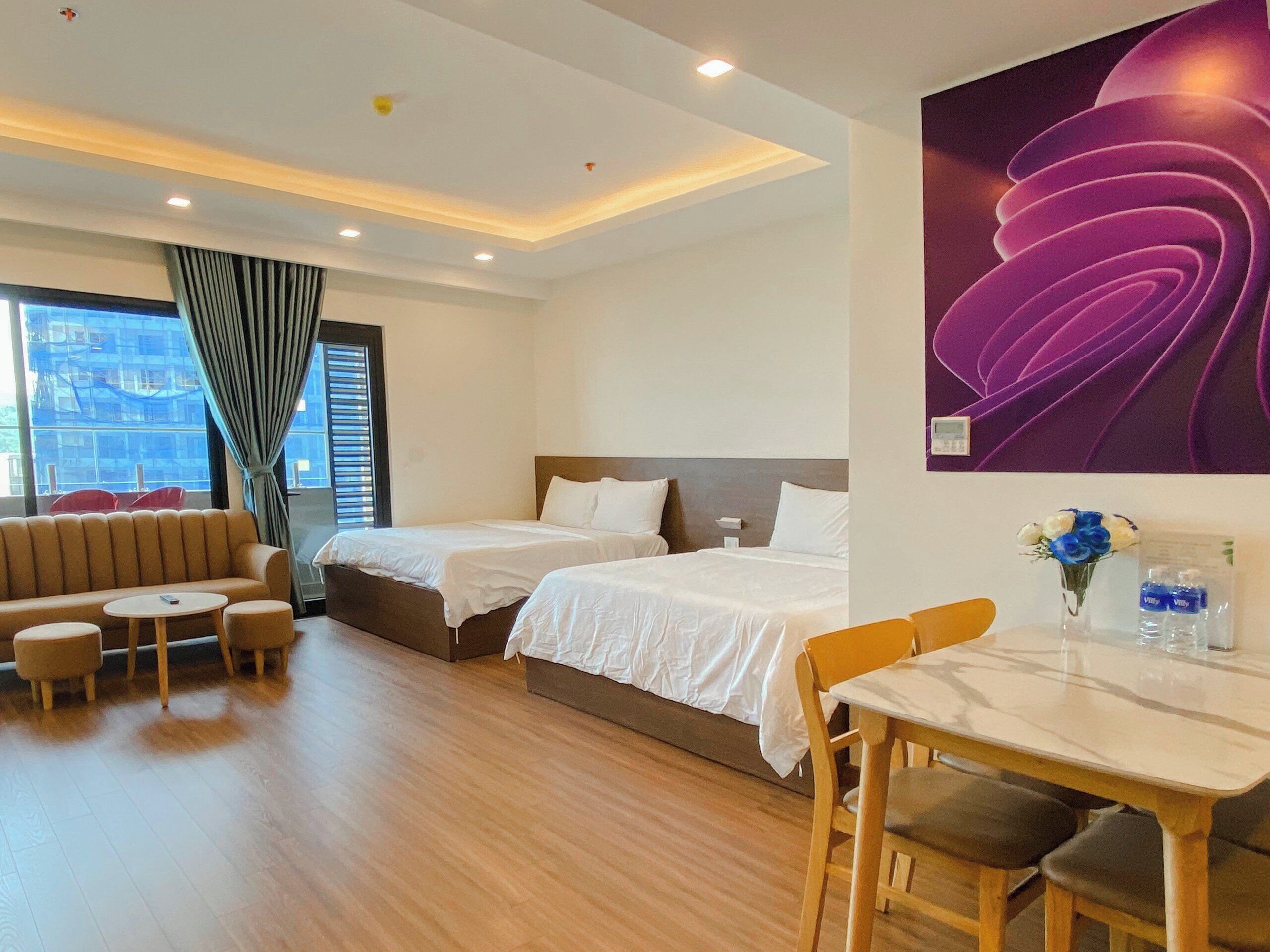 Een hotelkamer met twee bedden, een bank, een tafeltje en een stoel.