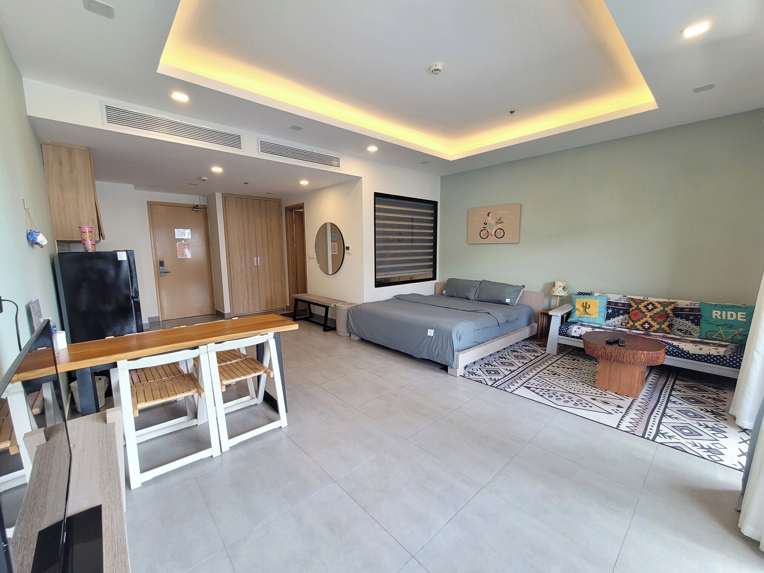 A modern bedroom with a bed, bedside table, and a sofa.