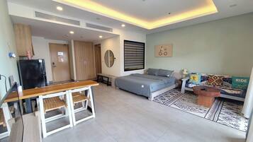A modern bedroom with a bed, bedside table, and a sofa.