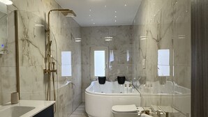 Een moderne badkamer met een groot bad, een aparte douche en een wastafel met spiegel.