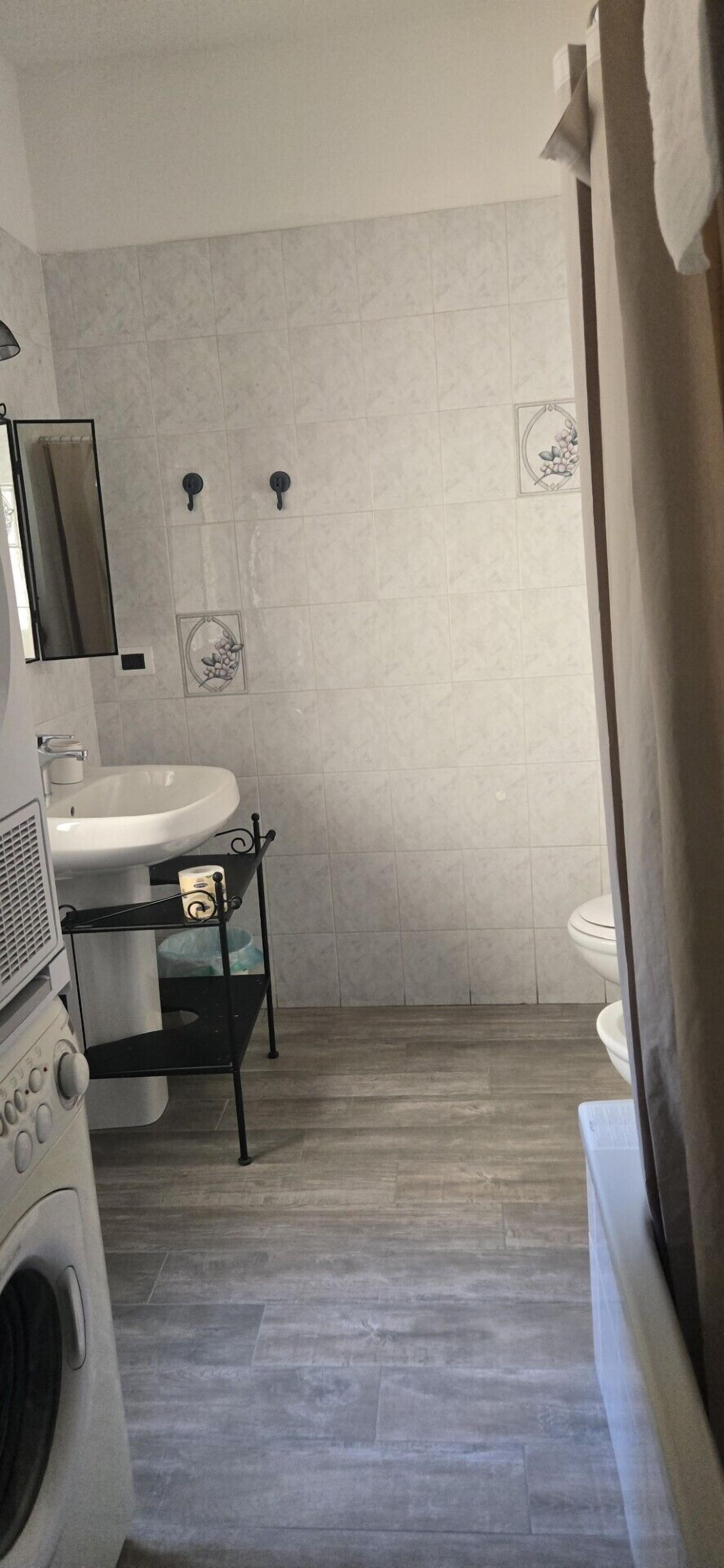 A modern bathroom with a sink, mirror, and toilet.