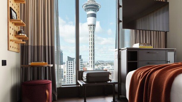A hotel room with a large window, a bed, a desk, and a chair. - Hotel Indigo Auckland by IHG (Auckland)