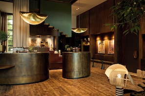 A modern lobby with a wooden floor, a reception desk, and a large plant. - Hotel Indigo Auckland by IHG (Auckland)