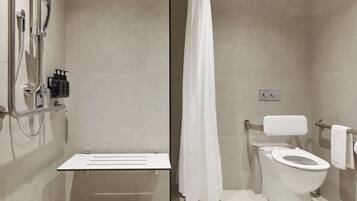 A modern bathroom with a shower, toilet, and a white sink.
