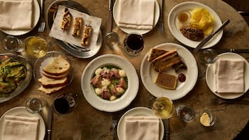 Una mesa dispuesta con varios platos, incluyendo pan, queso y una ensalada, que sugiere un ambiente para disfrutar de una comida.