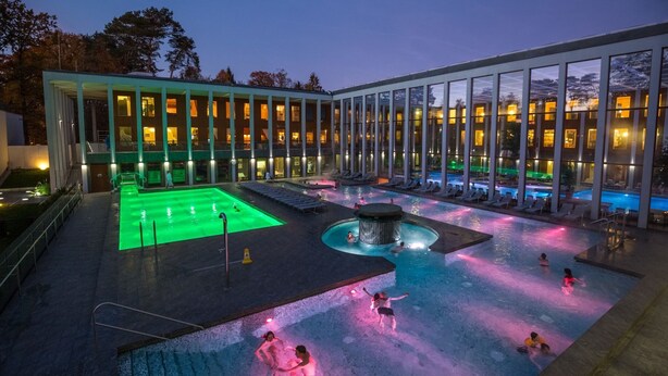 Un hôtel doté d’un espace piscine comprenant un jacuzzi et des chaises longues.