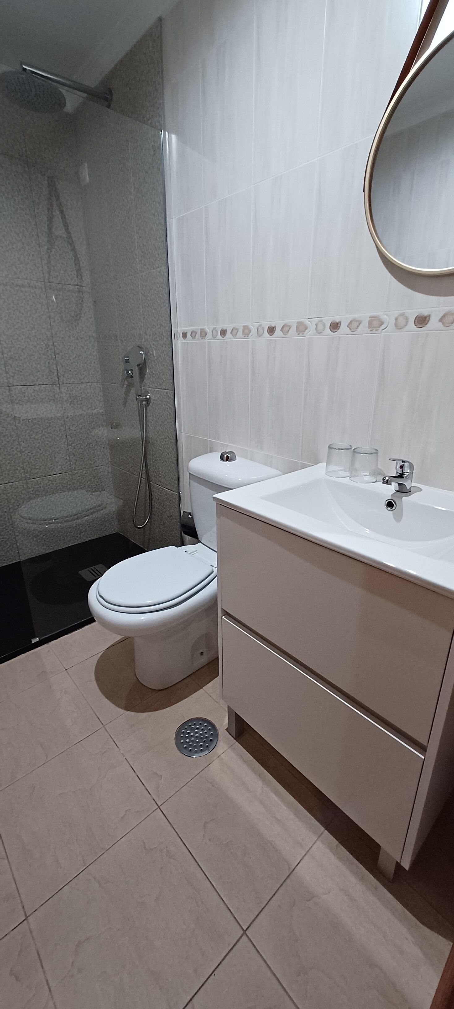 A modern bathroom with a toilet, sink, and shower.