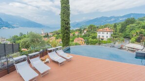 A rooftop pool with lounge chairs, a tall tree, and a view of a lake and mountains. - Villa Cosima in Bellagio With Private Pool (Bellagio)
