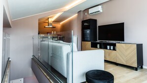 Um quarto moderno com cama em compartimento de vidro, televisão e um armário de madeira.