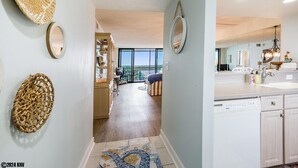 Una cocina moderna con alacenas blancas, lavavajillas y un ventanal con vistas al exterior.