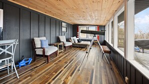 A wooden deck with a sofa, chairs, and a table. - Lakeview Lodge • Sleeps 14 • Game Room • Fire Pit (Bronston)