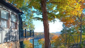 A stone building with a balcony overlooking a lake and autumn foliage. - Lakeview Lodge • Sleeps 14 • Game Room • Fire Pit (Bronston)