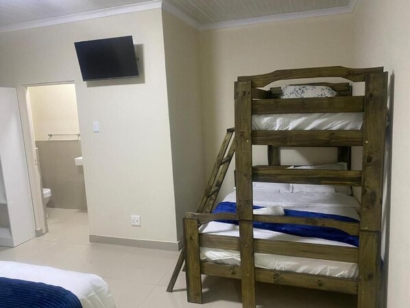 Un lit superposé avec un téléviseur fixé au mur au-dessus.