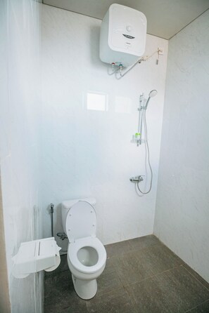 A bathroom with a toilet, a shower, and a wall-mounted heater. - VILLA BALIEM CHRIST (Jimbaran)