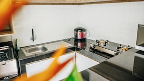 A modern kitchen with a gas stove, a coffee maker, and a sink. - VILLA BALIEM CHRIST (Jimbaran)