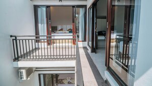 A modern balcony with a glass door leading to a bedroom. - VILLA BALIEM CHRIST (Jimbaran)