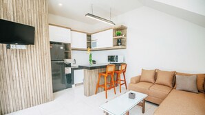 A modern living room with a sofa, a coffee table, and a TV mounted on the wall. - VILLA BALIEM CHRIST (Jimbaran)