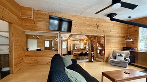 Een gezellig interieur van een vakantiehuisje met een zithoek, eethoek en keuken.