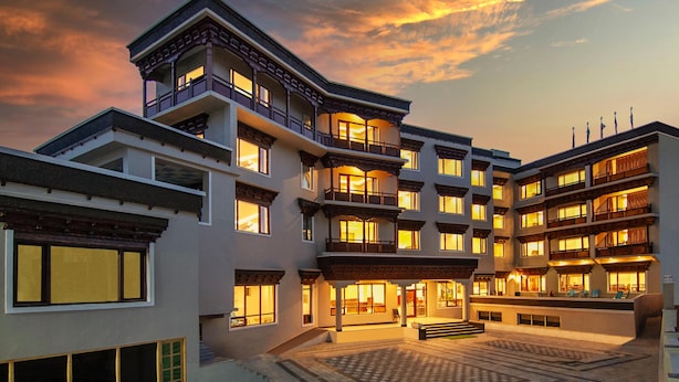 Un hotel de varios pisos con patio, balcones y un estilo arquitectónico tradicional.