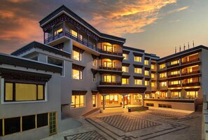 Un hotel de varios pisos con patio, balcones y un estilo arquitectónico tradicional.