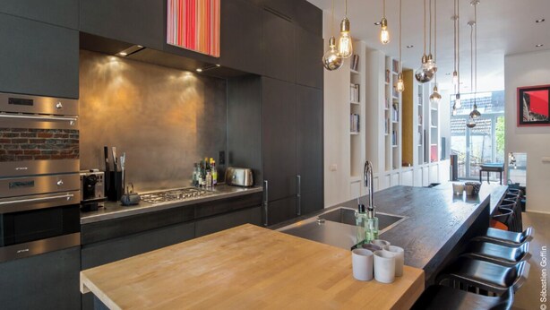A modern kitchen with a central island, stainless steel appliances, and pendant lighting. - Flagey Terrace Design residence (Brussels)