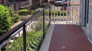 A narrow balcony with a metal railing, a red-tiled floor, and a view of adjacent buildings and parked cars. - SPACIOUS 90 SQM APARTMENT WITH BALCONIES, PRIVATE PARKING - RAFFAELE DE FERRARI (Roma)