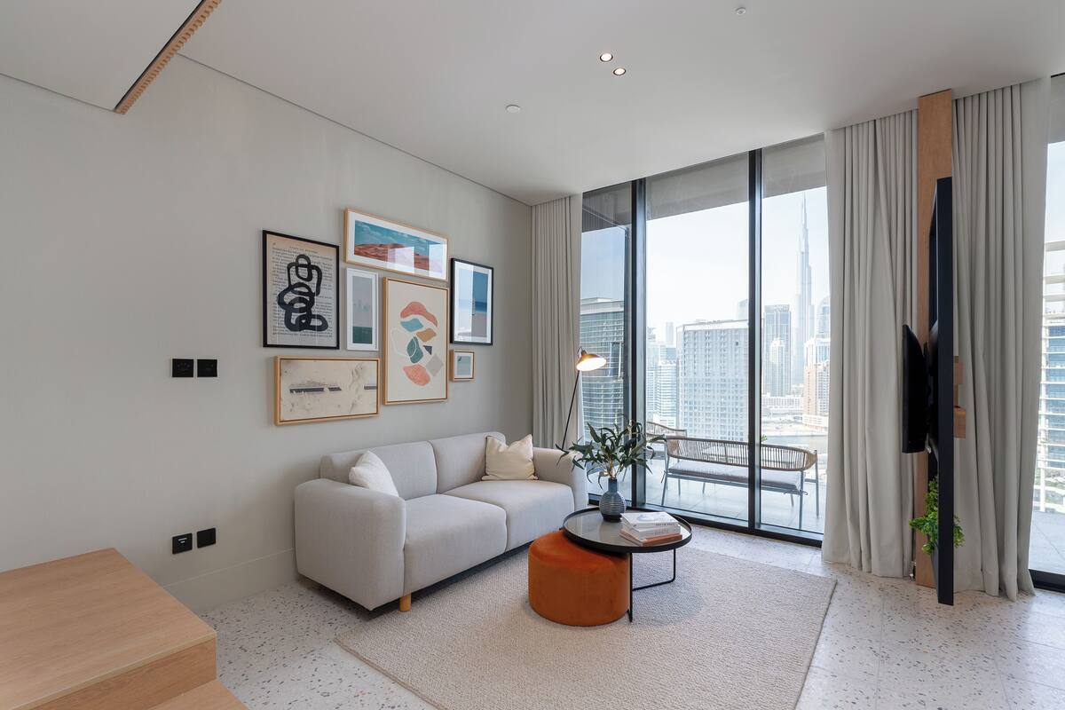 A modern living room with a sofa, coffee table, and artwork on the wall.