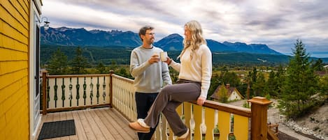 Eine Holzterrasse mit Geländer, mit Blick auf eine Berglandschaft.